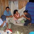 The shaman's wife blesses Manuel's wife's hands with smoke